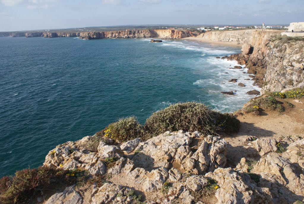 Vue depuis la forteresse de Sagrès sur un paysage typique de la région de l'Algarve, des falaises abruptes interrompues par des plages de sables fin.