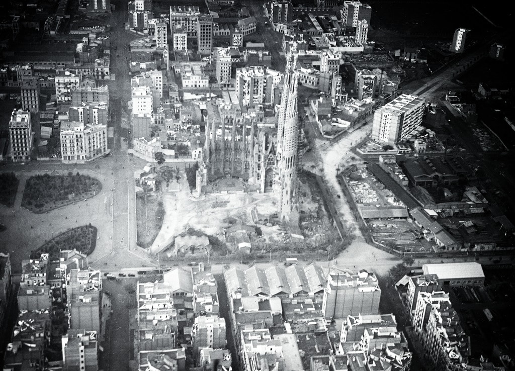 Sagrada Familia construite au milieu des champs et en 1930 entourée par des immeubles et des usines.