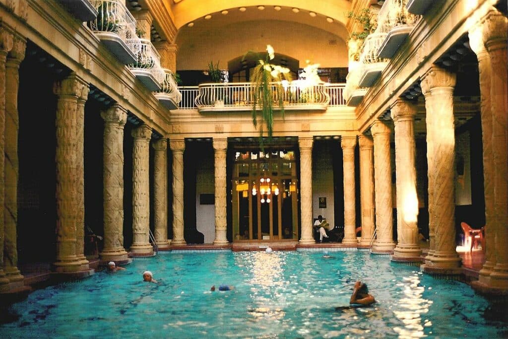 Piscine intérieure du bain Gellert à Budapest entourée de colonnes sculptées. Photo de Joe Mabel