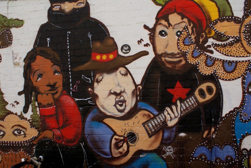 Numéro de charme et instant musical sur un mur de Christiania.