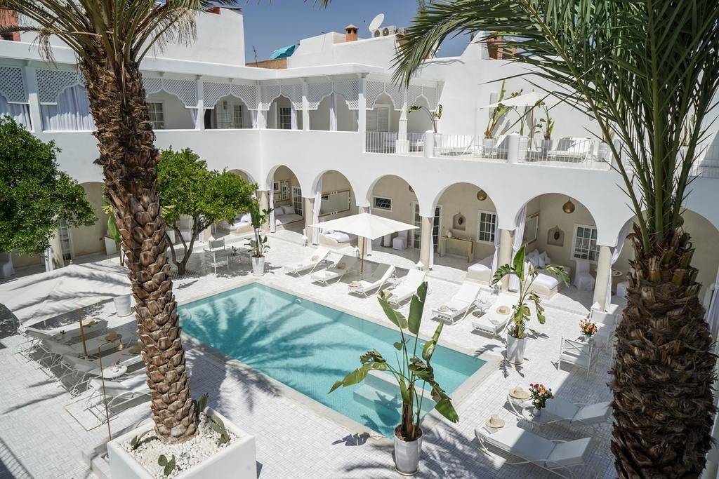 Au bord de la piscine de l'hôtel de charme du Palais Blanc Riad à Marrakech.