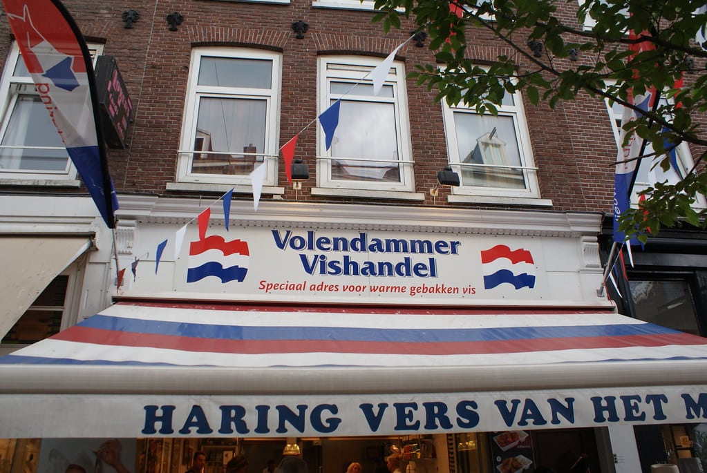 Un bon poissonnier au milieu du marché Cuypmarkt où manger un sandwich sur le pouce ou des harengs accompagnés de leur cornichon.