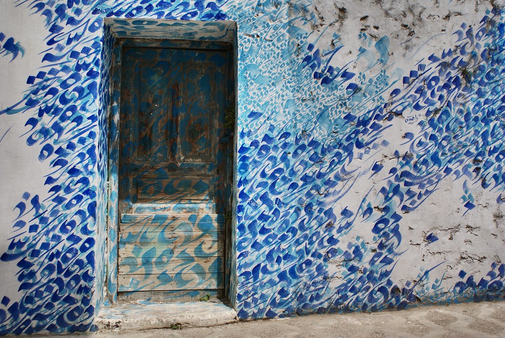 Jolie fresque de street art à Asilah entre calligraphie et ressac de la mer.
