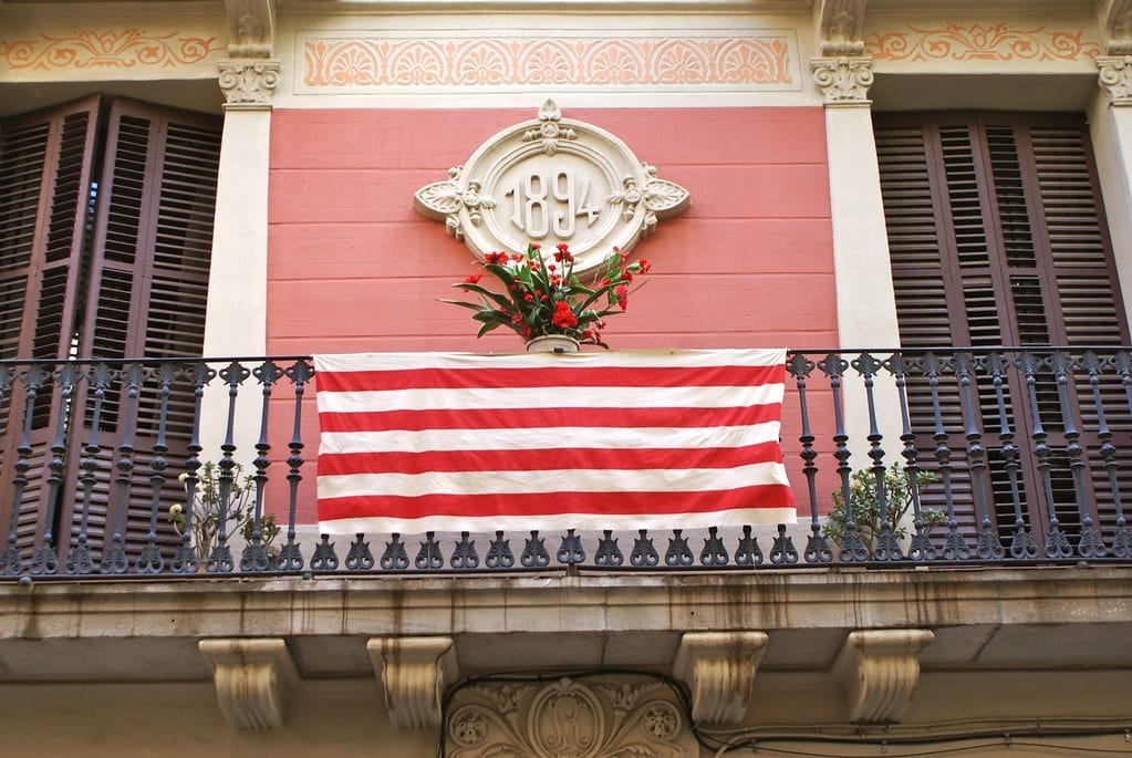 Façade du quartier de Gracia avec fleurs et drapeaux catalans.