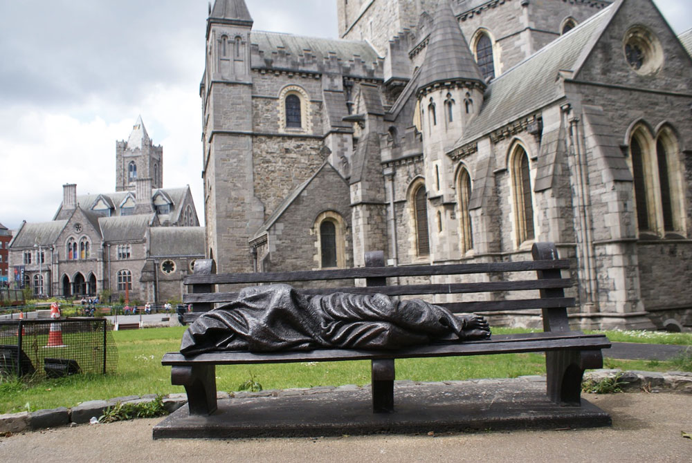 Statue devant la cathédrale Christchurch à Dublin représentant un sans abri portant les stigmates du Christ.