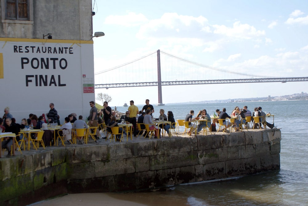 Terrasse du Ponto Final s'avançant dans le Tage sur fond de pont du 25 avril sur la rive sud de Lisbonne.