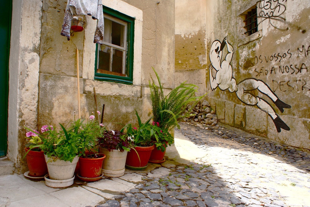 Ambiance village entre pots de fleurs et linge séchant à la fenêtre.