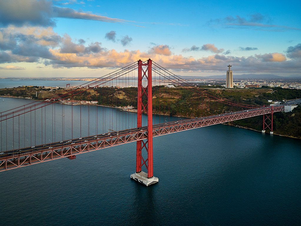 Vue sur le pont du 25 avril à Lisbonne avec la statue de Jésus roi en arrière plan. Photo de Deensel
