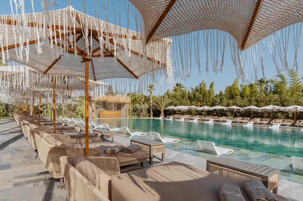 Transats au bord de la piscine Nommos à Marrakech.