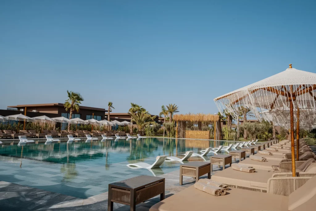 Transats au bord de la piscine Nommos à Marrakech.