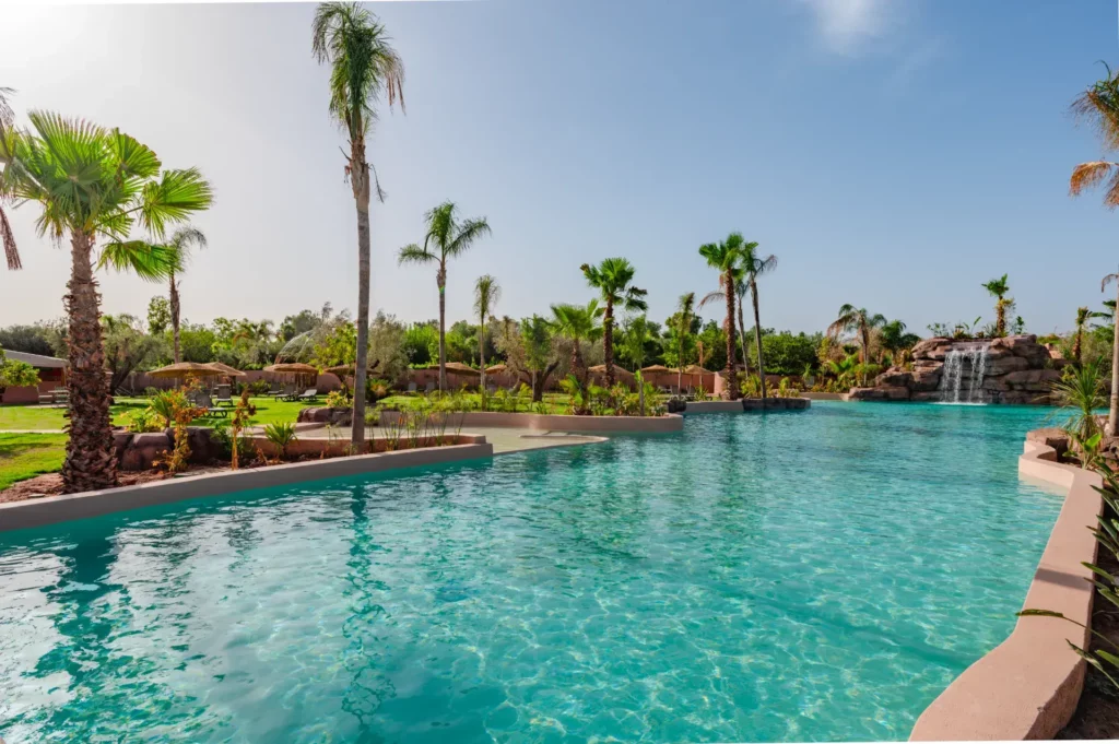 Piscine et palmiers à l'Oasis Lodge de Marrakech.