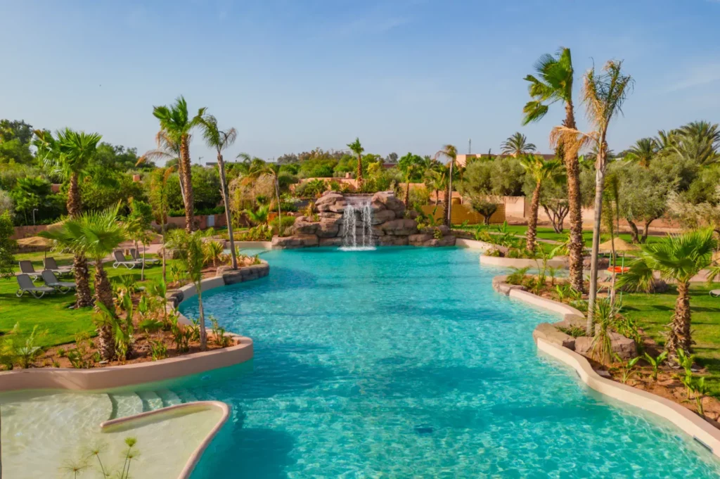 Piscine et palmiers à l'Oasis Lodge de Marrakech.