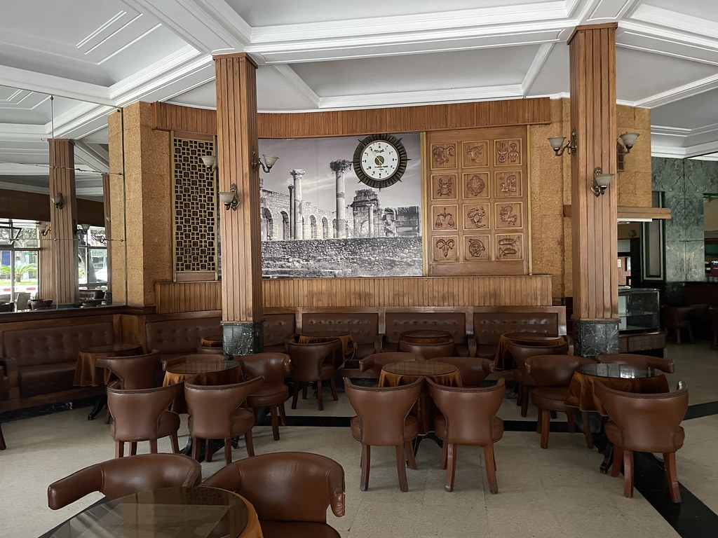 Intérieur art deco du Gran café de Paris à Tanger avec les signes du zodiaque sculptées en bois à droite de l'horloge.