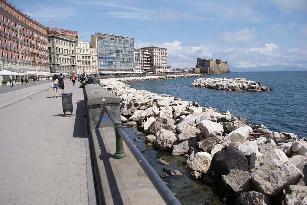 Via Partenope dans le quartier de Chiaia à Naples : Terrasses de restaurants et de cafés, grands hôtels avec vue sur le castel d’Ovo et la baie.