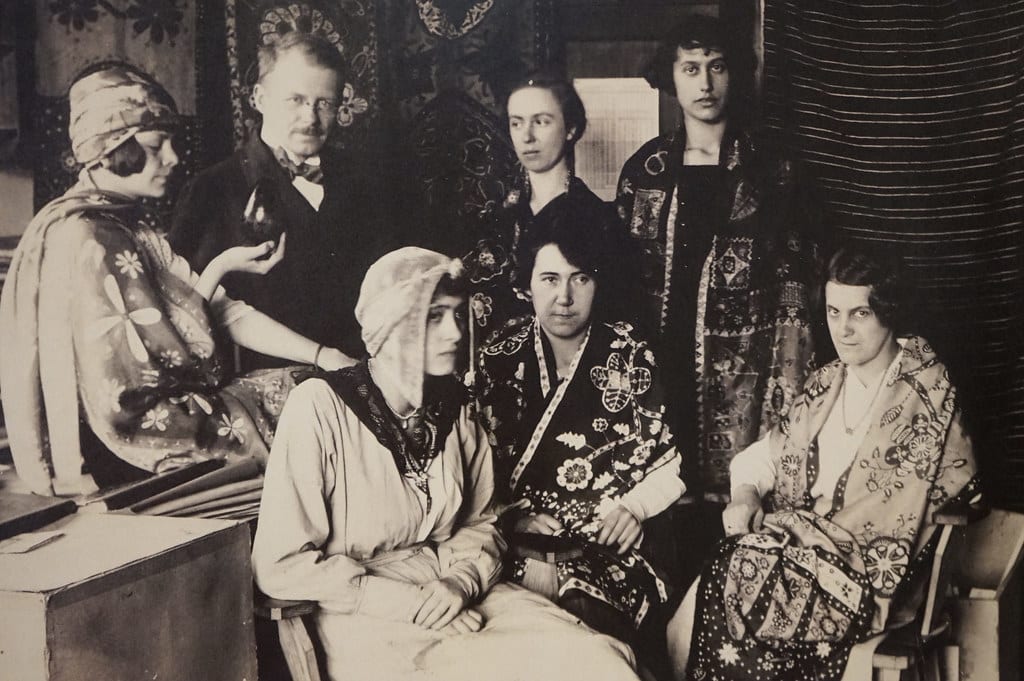 Antoni Buszek entouré de femmes portant des vêtement s imprimés en batik. Au musée ethnographique de Cracovie.