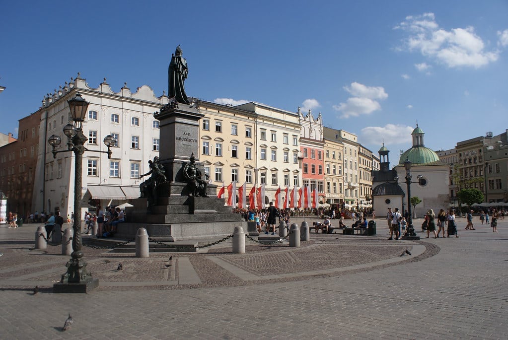 Derrière la statue du poète Adam Mickiewicz sur la place du marché : le Rynek de Cracovie.