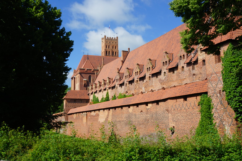 Mur du Chateau Moyen surplombés par la tour de Malbork.