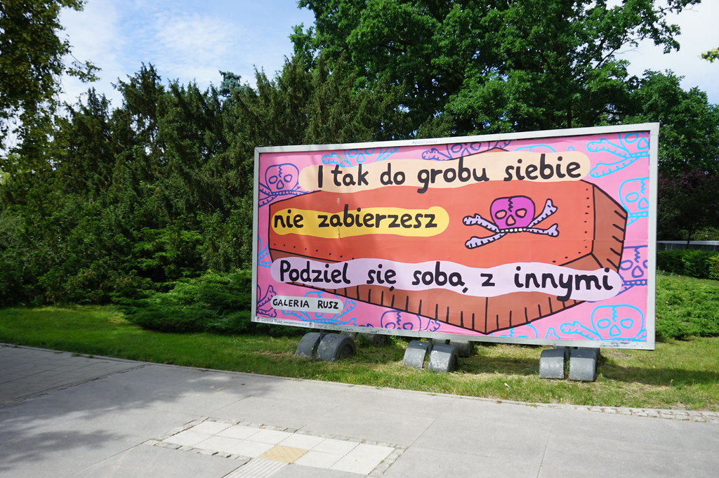 "Tu ne t'emporteras pas dans la tombe avec toi, partages toi avec les autres" message de la Galaria Rusz devant le Centre d'art contemporain Znaki Czasu à Torun.