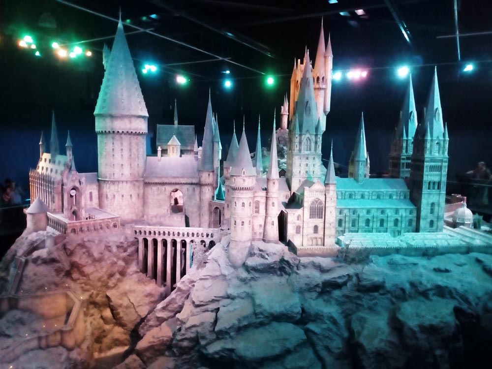 Maquette de Poudlard Studio Harry Potter près de Londres avec des visiteurs de par et d'autres pour avoir une idée de l'échelle.