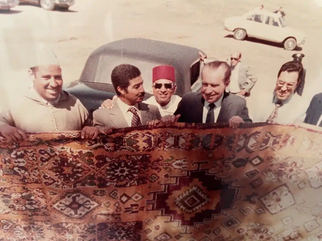 Nixon soulevant un tapis berbère au musée de la Légation américaine à Tanger.