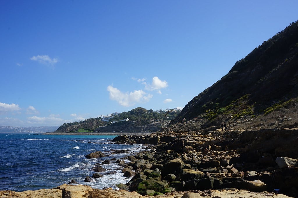 Rochers après la plage de Merkala à Tanger avec la Coline de Marchan dans le fond.