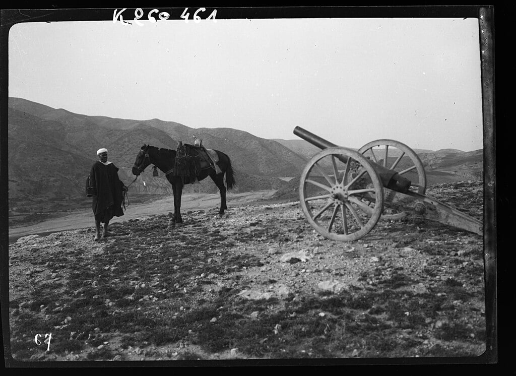 Cheval du leader indépendantiste Abd el Krim pres d'un canon Krupp abandonné par les Espagnols dans le Rif oriental.