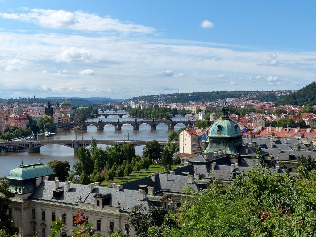 Vue sur les ponts de Prague et ses collines verdoyantes.