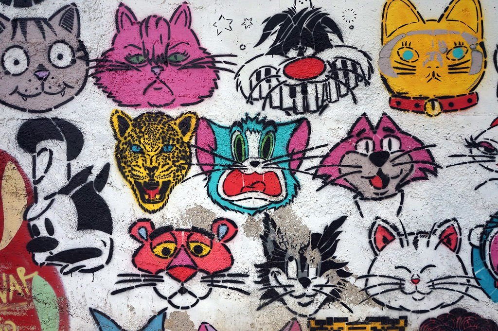 Street art avec des chats célèbres dans un parc de la ville.